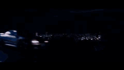 a blurry picture of two cars driving down a road at night