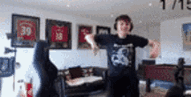 a man in a black shirt with the number 39 on it is dancing in a living room