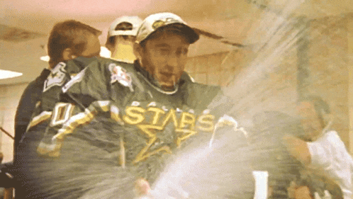 a man in a stars jersey is being sprayed with water