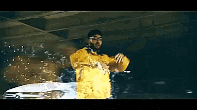 a man in a yellow jacket is standing next to a car