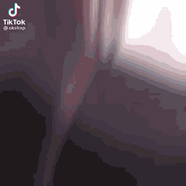 a tiktok video of a person walking in a dark room with a blurred background .