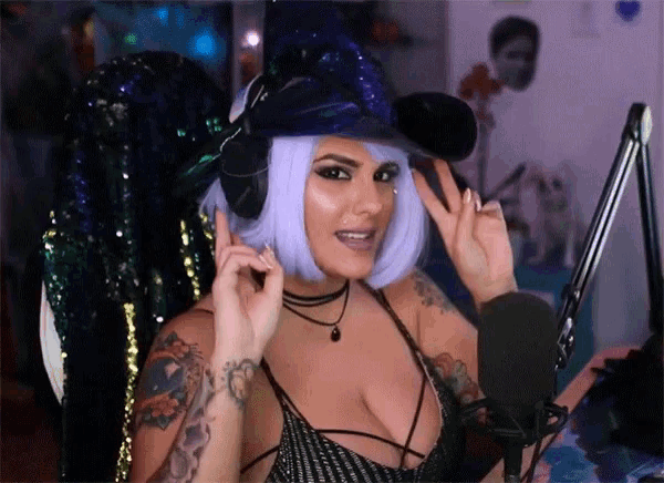 a woman wearing a purple wig and headphones is in front of a microphone