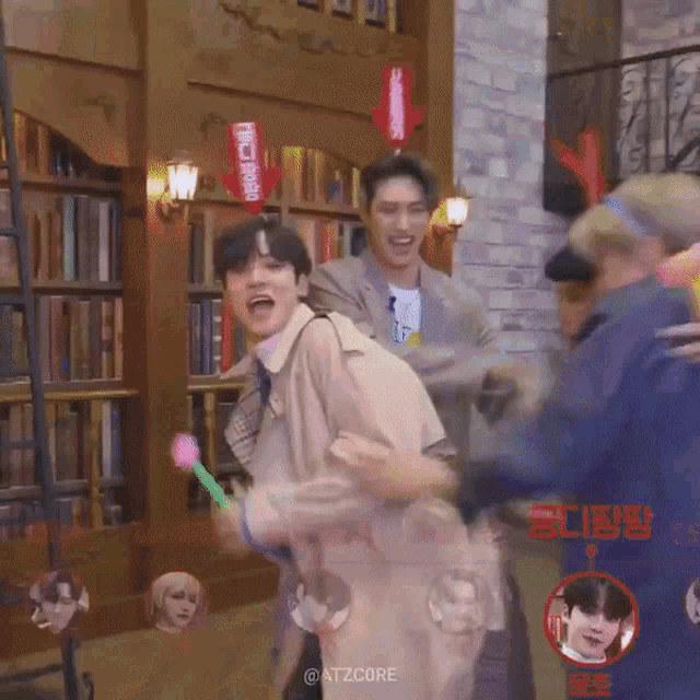 a group of men are playing with balloons in a room .