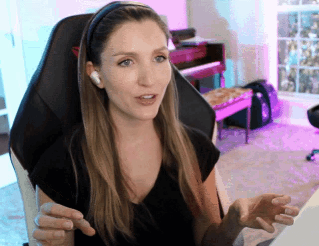 a woman wearing a headband and headphones is sitting in an office chair