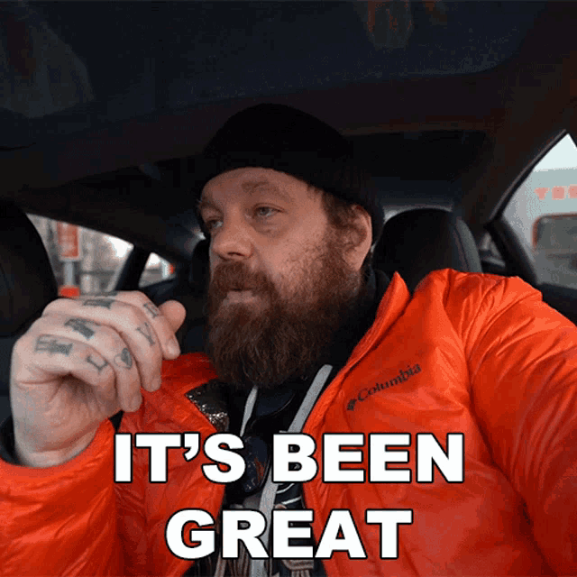 a man with a beard wearing an orange columbia jacket