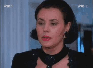 a woman is wearing a black dress and earrings and is on ptc11