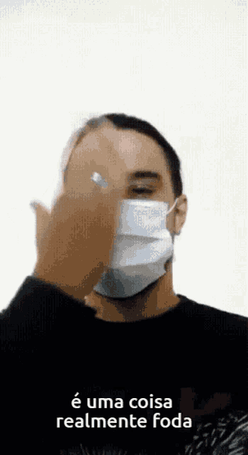 a man wearing a face mask with the words e uma coisa realmente foda below him