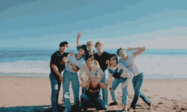 a group of people posing for a picture on the beach with one wearing a shirt that says miami