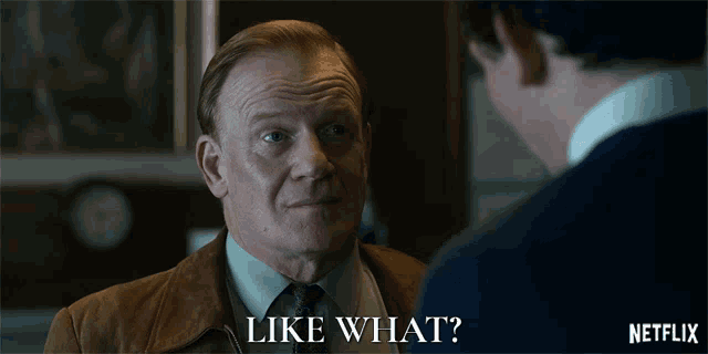 a man in a suit and tie is talking to another man with the words " like what " on the bottom