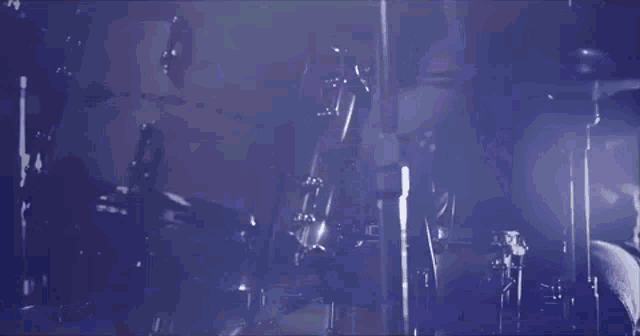 a man playing drums in a dark room