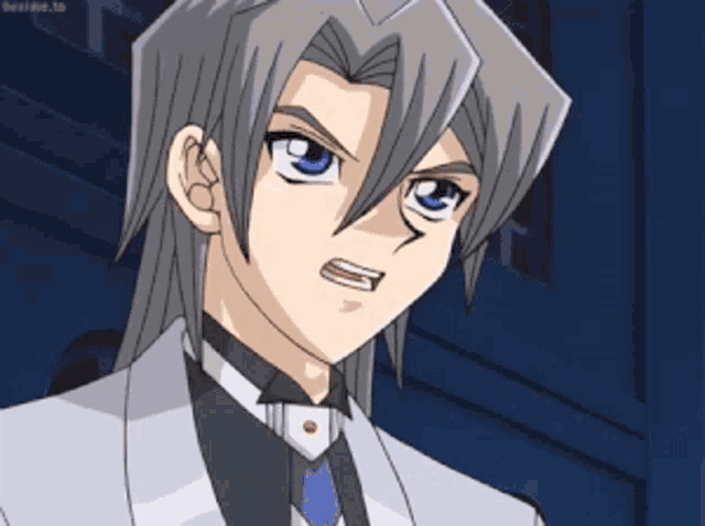 a man with gray hair and blue eyes is wearing a suit and tie