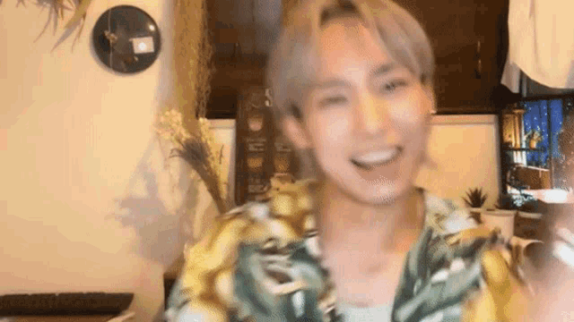 a man in a hawaiian shirt is smiling and looking at the camera .