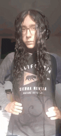 a man with long hair wearing a sierra nevada shirt