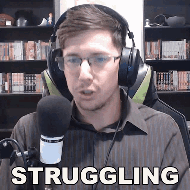 a man wearing headphones and glasses stands in front of a microphone with the word struggling above him