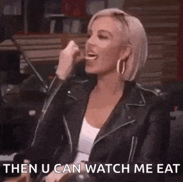 a woman in a leather jacket is laughing and saying `` then u can watch me eat ''