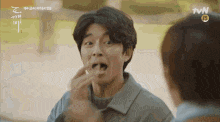a man is eating a piece of food with his mouth open .