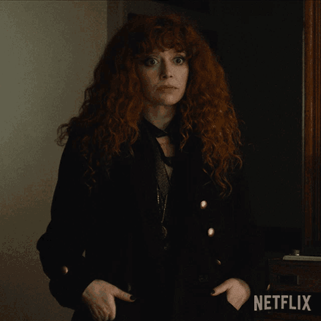 a woman with red hair is standing next to a netflix sign