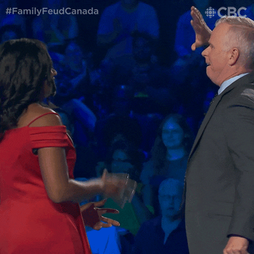 a man in a suit and tie is dancing with a woman in a red dress with the hashtag #familyfeud canada