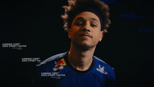 a man is wearing a blue shirt with red bull on it