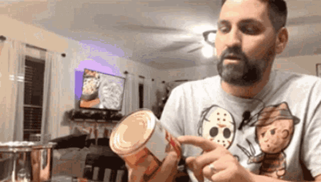 a man in a freddy krueger shirt is holding a can