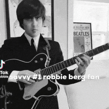a man in a suit and tie is playing a guitar