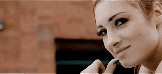 a close up of a woman 's face with her hand on her chin
