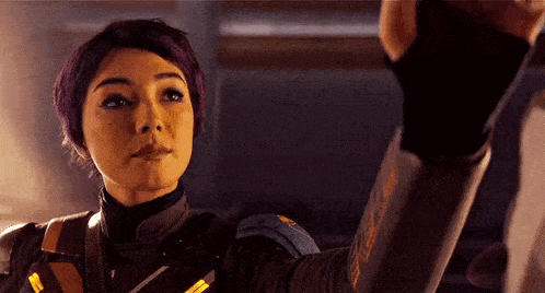 a woman with purple hair is taking a picture of herself with her hand .