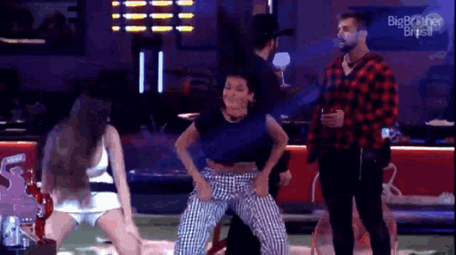 a man in a plaid shirt is standing next to a woman in a blue shirt dancing on a stage .