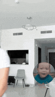 a man is standing in a room with a picture of a baby in a circle