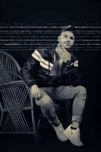a black and white photo of a man sitting in a chair