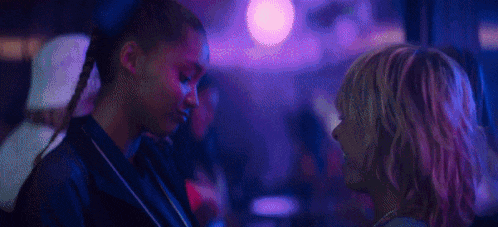a group of people are standing next to each other in a room with purple lights .