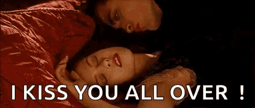 a man and a woman are kissing in bed with the words `` i kiss you all over '' above them .