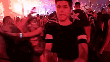 a young man is dancing in a crowd of people at a concert .