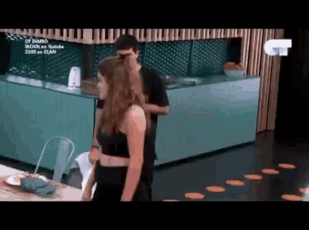 a man and woman are standing next to each other in a kitchen .