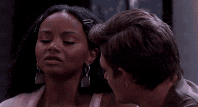 a man and a woman are looking at each other and the woman has a clip in her hair