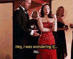 a woman in a red dress is standing next to a man in a tuxedo ..