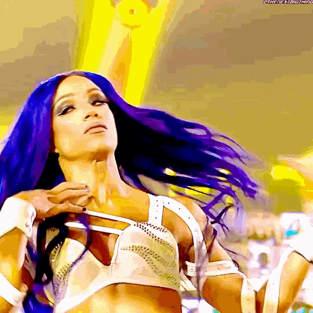 a woman with purple hair is wearing a white top with rhinestones