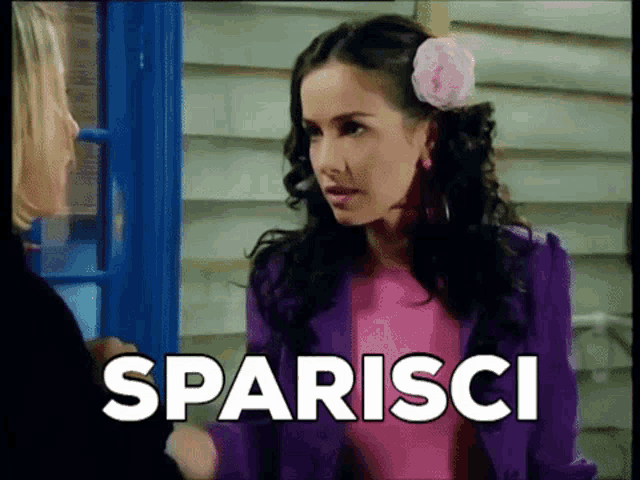 a woman with a flower in her hair is talking to another woman and the word sparisci is above her