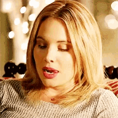 a close up of a woman with her mouth open wearing a sweater .