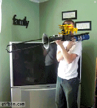 a man playing a trombone in front of a tv with a family sign on the wall