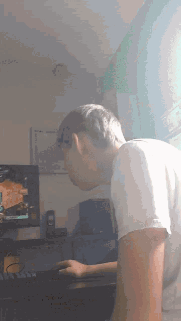 a young man is playing a video game on a computer monitor