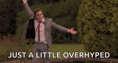 a man in a suit and tie is dancing in a park with his arms in the air .