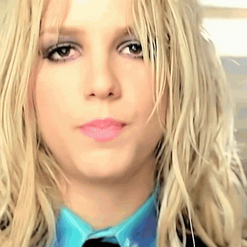 a close up of a woman 's face wearing a blue shirt and tie