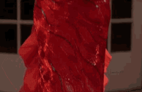dolly parton is wearing a red dress with ruffled sleeves .