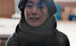 a woman wearing a scarf around her neck is smiling for the camera
