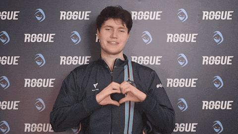 a man is making a heart shape with his hands in front of a wall that says rogue