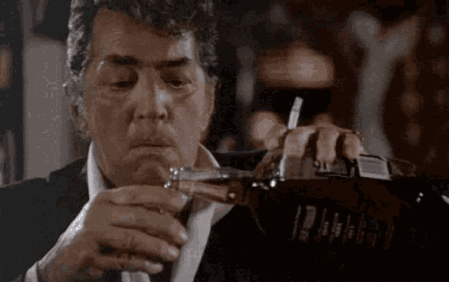 a man in a suit is pouring a glass of whiskey from a bottle