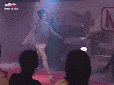 a woman is walking down a runway in front of a sign that says barra