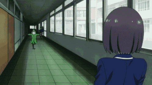 a girl in a blue jacket is standing in a hallway looking out a window ..