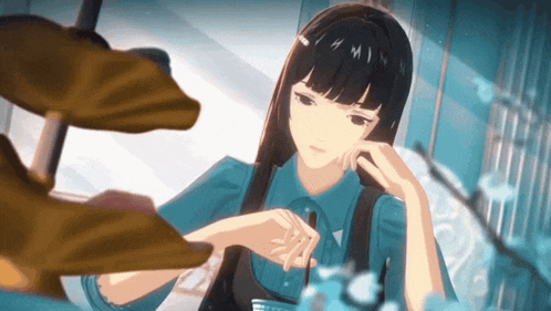 a girl with long black hair and a blue shirt is looking at herself in a mirror